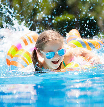 Child with inflatable toy ring float in swimming pool. Little girl learning to swim and dive in outdoor pool of tropical resort. Swimming with kids. Healthy sport activity for children. Water fun.