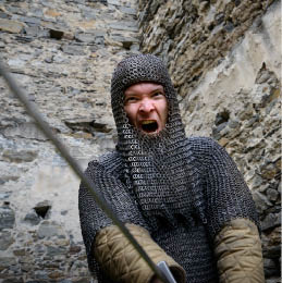 Ritter mit Kettenhemd schl gt schreiend mit dem Schwert zu